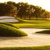 A sunny view of green protected by bunkers at Gateway Golf & Country Club