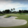A view of a green protected by undulating bunkers and a pond at La Gorce Country Club