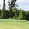 A view of a hole protected by a bunker at Forest Oaks Golf Club