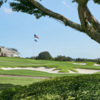 A view of the clubhouse and a green surrounded by bunkers at Country Club of Florida.