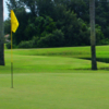 A view of a green with water in background at The Groves Golf Course.