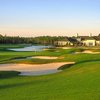 A view of a green protecteed by bunkers with clubhouse in background at St. Johns Golf & Country Club