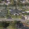 A view of the clubhouse surrounded by tennis courts and swimming pool on the right at Bardmoor Golf & Tennis Club.